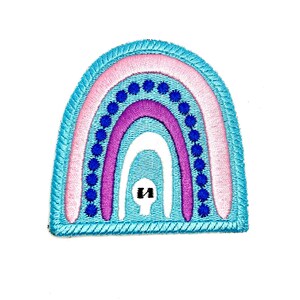 May include: A blue, pink, purple and white rainbow embroidered patch with a white outline and blue dots.