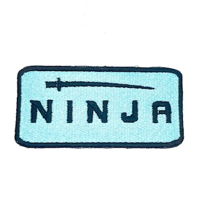 May include: A light blue rectangular embroidered patch with a black outline. The patch features a black silhouette of a sword and the word "NINJA" in black lettering.