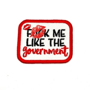 May include: Red and white embroidered patch with the text "F**k me like the government" and a red lip print.