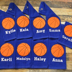May include: Eight blue towels with orange basketballs and white embroidered names: Kylie, Kaia, Amy, Emma, Sarah, Karli, Madalyn, Haley, and Anna.