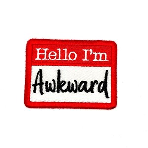 May include: Red and white name tag with the text "Hello I'm Awkward" in black embroidery.