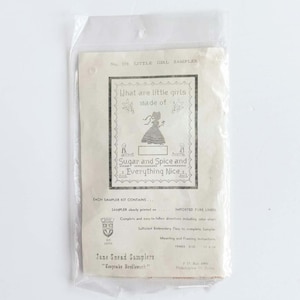 May include: A white ceramic mug with a black handle and the text "But First, Coffee" in a bold, black font. The mug is set against a neutral background, highlighting its simple design.