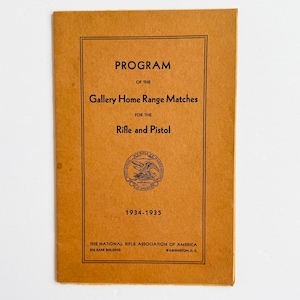 Könnte beinhalten: Ein Vintage-Programmcover in Braun mit schwarzem Text. Der Text lautet "PROGRAMM der Gallery Home Range Matches für Gewehr und Pistole" mit den Jahren 1934-1935. Die National Rifle Association of America ist ebenfalls aufgeführt.