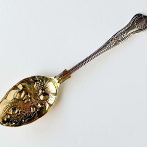 Cuchara de servir antigua de plata con cuenco dorado repujado