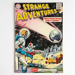 May include: A vintage comic book cover titled "Strange Adventures." The cover features astronauts, a comet, and the Earth. The comic book has the text "When Earth Turned Into A Comet!" and "An Atomic Knights Story!"