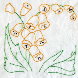 Puede incluir: Diseño floral bordado con flores naranjas en forma de campana y detalles negros, junto con hojas verdes, sobre un fondo blanco. El bordado a mano le da un aspecto delicado y encantador, ideal para arte textil o decoración del hogar.