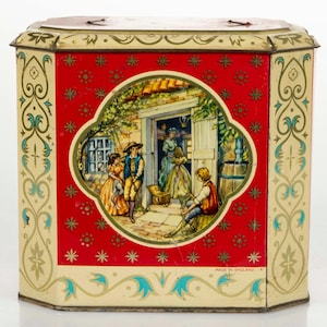 Puede incluir: Caja de lata vintage con fondo rojo e ilustración ovalada central de personas frente a un edificio. La caja tiene un borde crema con detalles florales y turquesas. Se lee "MADE IN ENGLAND".