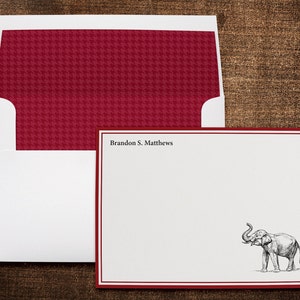 May include: Red and white stationery set with a red and white houndstooth pattern envelope and a white card with a red border and a black and white illustration of an elephant. The card has the text "Brandon S. Matthews" printed at the top.