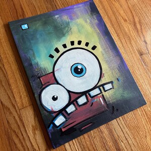 May include: A colorful abstract painting of a cartoon face with a large eye, a smaller eye, and a red mouth with teeth. The background is a gradient of green, yellow, and purple.