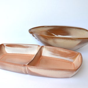 May include: Two ceramic serving dishes in a brown and white glaze. The larger dish is oval shaped and the smaller dish is rectangular with two divided sections.