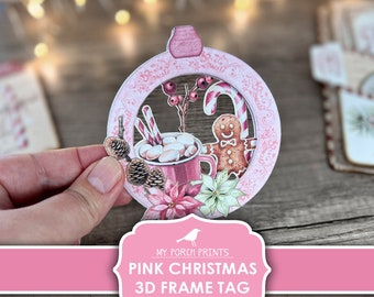 Puede incluir: Etiqueta de marco 3D de Navidad rosa imprimible, con un hombre de jengibre, bastones de caramelo, una taza de chocolate caliente con malvaviscos, piñas y poinsettias. La etiqueta está diseñada para ser impresa y ensamblada en un marco 3D.