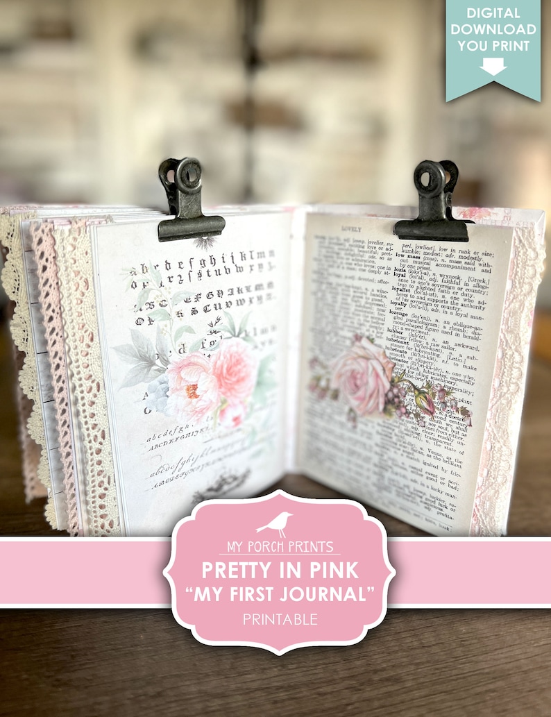 Op de afbeelding: Een printbaar dagboek met een roze en wit bloemenontwerp. Het dagboek is gesloten en wordt bij elkaar gehouden door twee metalen clips. De tekst "My Porch Prints" staat op de voorzijde, samen met de tekst "Pretty in Pink" en "My First Journal".