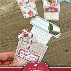 K&ouml;nnte beinhalten: Druckbare Weihnachts-Kaffeebecher-Geschenk-Etiketten mit einer versteckten Notiz im Inneren. Die Etiketten zeigen einen roten und wei&szlig;en Zuckerstock, einen Stechpalmenzweig und ein festliches Design.