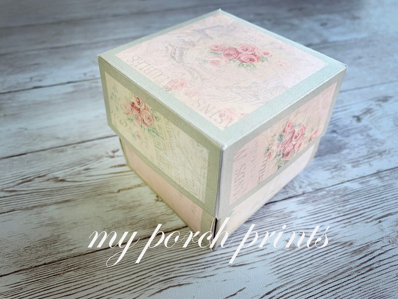 May include: A square, pale green and pink gift box with a floral design and the text "Sentiments" and "Wishing you" on the sides.