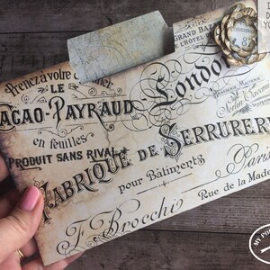 May include: Vintage-style printable envelope with the text "Cacao-Payraud en feuilles Produit Sans Rival Fabrique de Serrurerie pour Batiments F Brocchi Rue de la Madeleine Paris" in black script on a cream background.