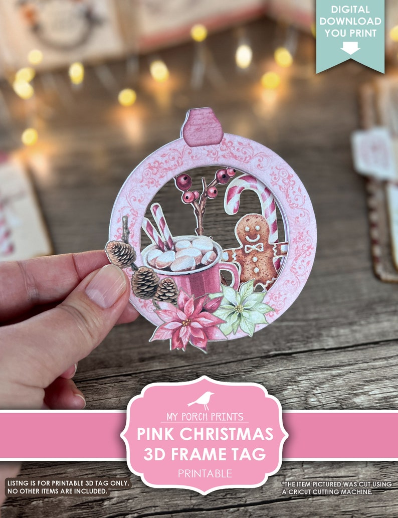 Puede incluir: Etiqueta de marco 3D de Navidad rosa imprimible. La etiqueta presenta un c&iacute;rculo rosa con un borde blanco y una escena de invierno en su interior. La escena incluye una taza de chocolate caliente con malvaviscos, un hombre de jengibre, bastones de caramelo y poinsettias.