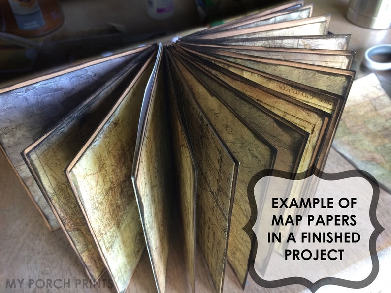 Puede incluir: Primer plano de un libro hecho con papeles de mapas antiguos. El libro est&aacute; abierto y las p&aacute;ginas est&aacute;n en abanico. El texto "EXAMPLE OF MAP PAPERS IN A FINISHED PROJECT" es visible en la imagen.