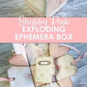 May include: A shabby pink exploding box with a floral design. The box is open and the inside is filled with small, decorative items. The box is made of paper and has a vintage look.