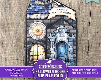 May include: A Halloween-themed flip-flap folio featuring a haunted house design. The house has a blue door, stained-glass window, and a bat on the roof. The folded size is approximately 7x5 inches.