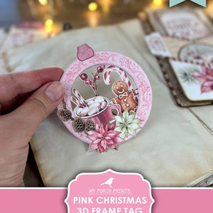 Puede incluir: Etiqueta de marco 3D de Navidad rosa imprimible. La etiqueta presenta un c&iacute;rculo rosa con un hombre de jengibre, bastones de caramelo, una taza de chocolate caliente con malvaviscos y una flor de pascua.