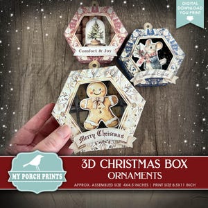 May include: Three printable 3D Christmas box ornaments. The ornaments feature a gingerbread man, a Christmas tree in a snow globe, and a mouse holding a banner that says "Peace on Earth". The ornaments are printed on white cardstock with colorful details. The ornaments are approximately 4x4.5 inches when assembled. The print size is 8.5x11 inches.