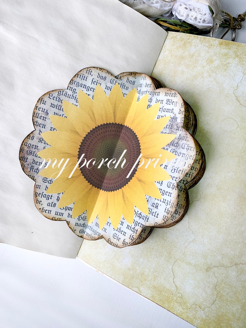 K&ouml;nnte beinhalten: Eine Papier-Bastel-Sonnenblume mit gelben Bl&uuml;tenbl&auml;ttern und einer braunen Mitte. Die Sonnenblume ist aus Seiten eines Buches mit gedrucktem Text gefertigt.