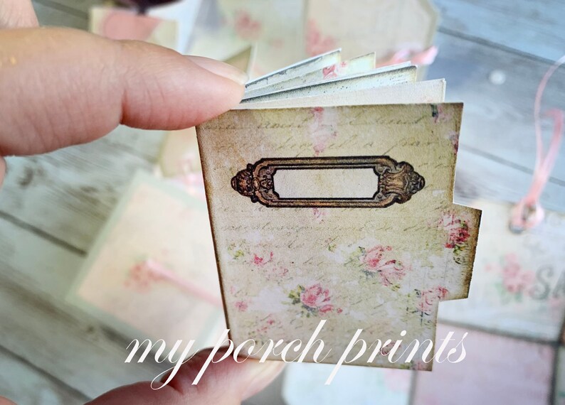 May include: A small, vintage-style journal with a floral design and a blank label. The journal is closed and has a worn, aged look.