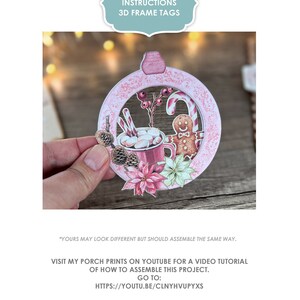 Puede incluir: Una etiqueta de marco 3D rosa y blanca con un tema navide&ntilde;o de invierno. La etiqueta presenta un hombre de jengibre, una taza de chocolate caliente con malvaviscos, bastones de caramelo y pi&ntilde;as. La etiqueta est&aacute; decorada con un borde festoneado rosa y blanco. El texto "MY PORCH PRINTS INSTRUCTIONS 3D FRAME TAGS" est&aacute; en la parte superior de la imagen. El texto "VISIT MY PORCH PRINTS ON YOUTUBE FOR A VIDEO TUTORIAL OF HOW TO ASSEMBLE THIS PROJECT. GO TO: HTTPS://YOUTU.BE/CLNYHVUPYXS OR GO TO YOUTUBE AND SEARCH FOR: "MY PORCH PRINTS 3D FRAME TAG" est&aacute; en la parte inferior de la imagen.