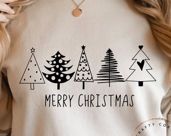 Könnte beinhalten: Ein beiger Pullover mit einer schwarzen Grafik von fünf stilisierten Weihnachtsbäumen und dem Text "Merry Christmas".