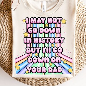 May include: A white t-shirt with a rainbow design and the text "I may not go down in history but I'll go down on your dad".