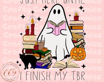 Pode incluir: Um fantasma branco lendo um livro rosa com uma pilha de livros, um gato preto, uma abóbora e velas. O texto diz "Just here until I finish my TBR".