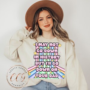 May include: A white sweatshirt with a rainbow graphic and the text "I may not go down in history but I'll go down on your dad".