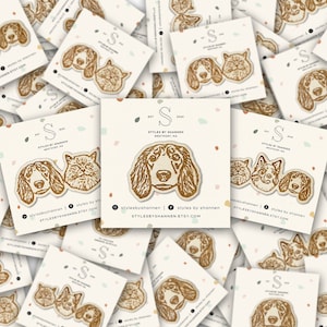 May include: A pile of white cards with brown illustrations of dogs and cats. The cards have the text "Styles by Shannen" and a website address.