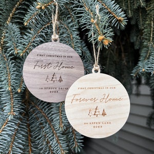 Puede incluir: Dos adornos navide&ntilde;os de madera con el texto "Primera Navidad en nuestro primer hogar" y "Primera Navidad en nuestro hogar para siempre" con el a&ntilde;o y la direcci&oacute;n.