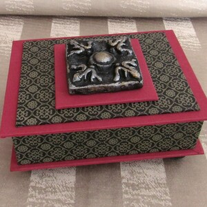 Kamakura Dynasty Box with a Black and Silver Medallion tile, covered with Red Book Cloth and Black and Gray Specialty Paper