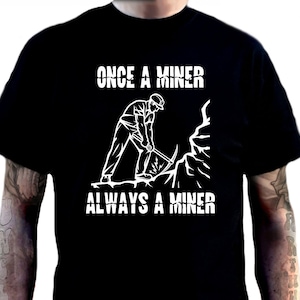 May include: Black t-shirt featuring a white graphic of a miner with a pickaxe, and the text "ONCE A MINER ALWAYS A MINER". Additional shirt colours are shown in the image.