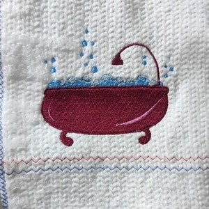 Può includere: Asciugamano da cucina bianco con un ricamo a forma di vasca da bagno rossa con acqua blu e una doccia.