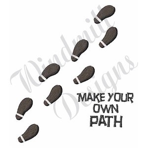 May include: A design featuring a series of black footprints with white accents, arranged in a diagonal pattern. The text "MAKE YOUR OWN PATH" is written in black below the footprints.