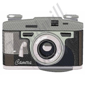 May include: A vintage-style camera with a silver body, black lens, and a brown leather strap. The camera has a white label that says "Camera".