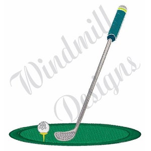 May include: A green golf putting green with a white golf ball on a tee and a silver golf club with a blue and green handle.