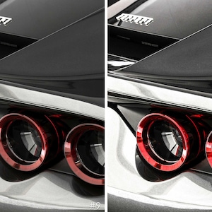 May include: Close-up of the rear end of a black car with red taillights. The car has a silver trim around the taillights and a silver trim around the rear window. The car has a Ferrari logo on the back.