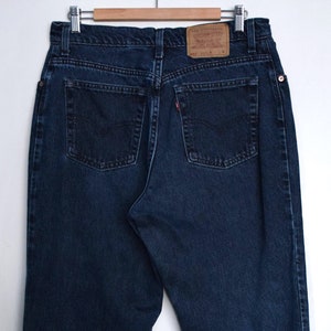 Puede incluir: Un par de pantalones vaqueros de mezclilla azul oscuro con una etiqueta de la marca Levi's en el bolsillo trasero.