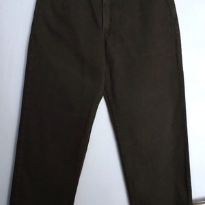 May include: Dark brown straight-leg jeans with a button fly and belt loops. The jeans have a faded look and are made of a soft, comfortable fabric.