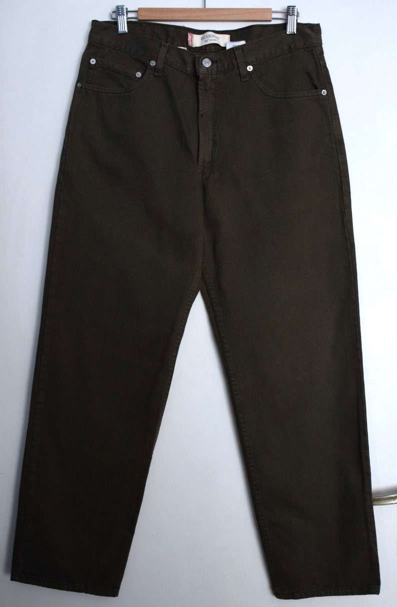 May include: Dark brown straight-leg jeans with a button fly and belt loops. The jeans have a faded look and are made of a soft, comfortable fabric.
