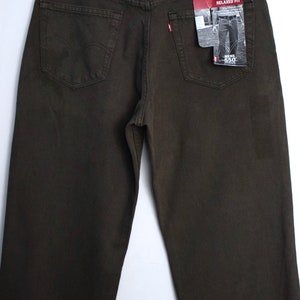 May include: A pair of dark brown relaxed fit jeans with a Levi's tag on the back pocket. The tag says "Men's 550 Relaxed Fit".