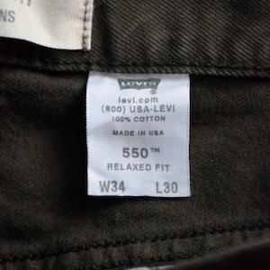 May include: White Levi's tag with black text. The tag says "levi.com (800) USA-LEVI 100% COTTON MADE IN USA 550 TM RELAXED FIT W34 L30"