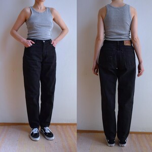 Peut inclure: Jean noir taille haute et coupe droite. Le jean est port&eacute; avec un d&eacute;bardeur gris et des baskets noires et blanches. Le jean a une conception classique &agrave; cinq poches.