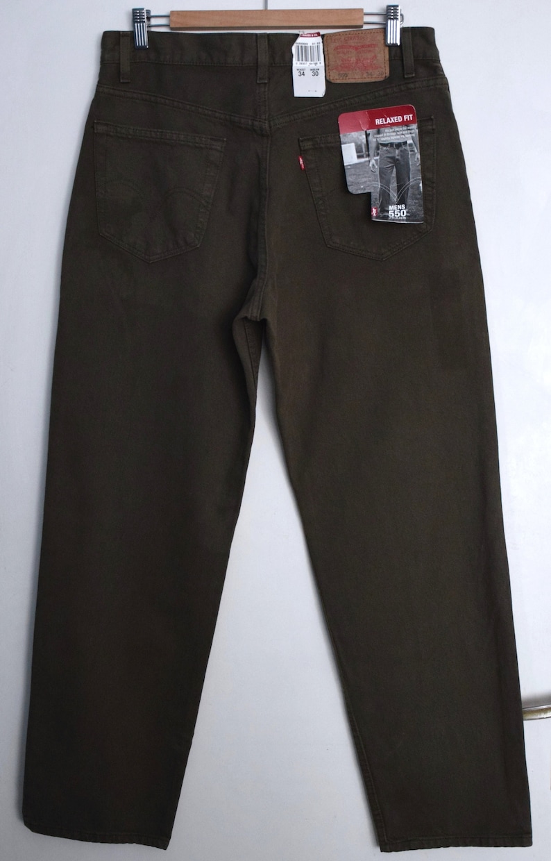 May include: A pair of dark brown relaxed fit jeans with a Levi's tag on the back pocket. The tag says "Relaxed Fit" and "550". The jeans are size 34 x 30.