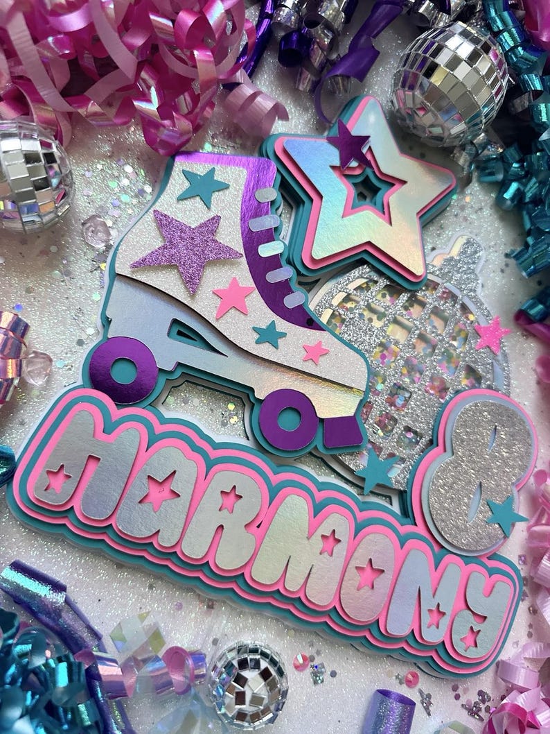 May include: A colourful party decoration with the name "Harmony" in large, glittery letters. The decoration features a roller skate, a disco ball, and stars. The colours are pink, blue, purple, and silver.