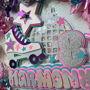 May include: A silver glitter roller skate with a pink and purple trim, a silver glitter disco ball, and a silver glitter number eight. The words "Harmony" are written in pink and white glitter letters with a teal border.